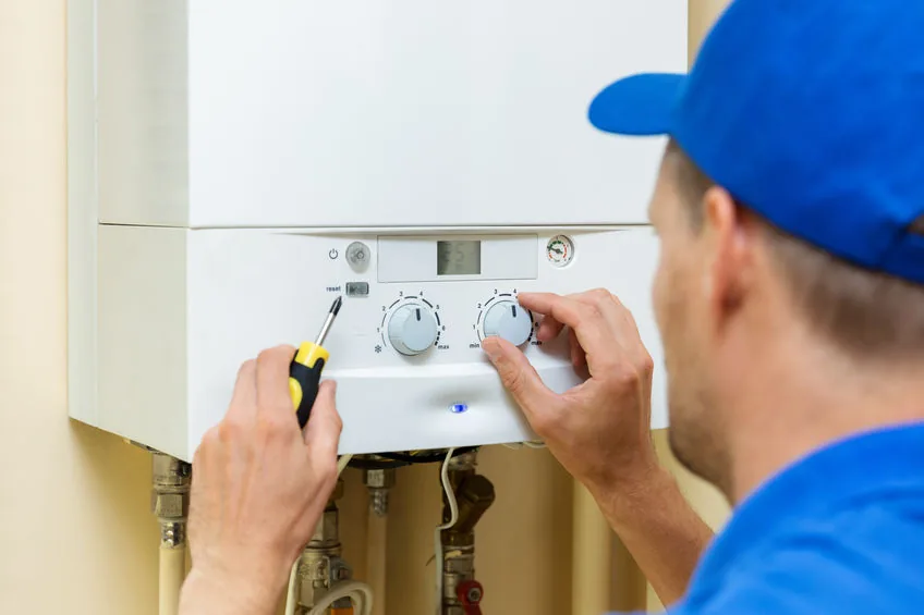 Installateur werkt aan een verwarmingsinstallatie met tablet